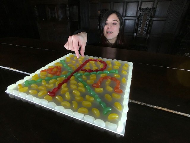 conservation assistant mary girerd with jelly bean chi-ro symbol which features on the stained glass panel
